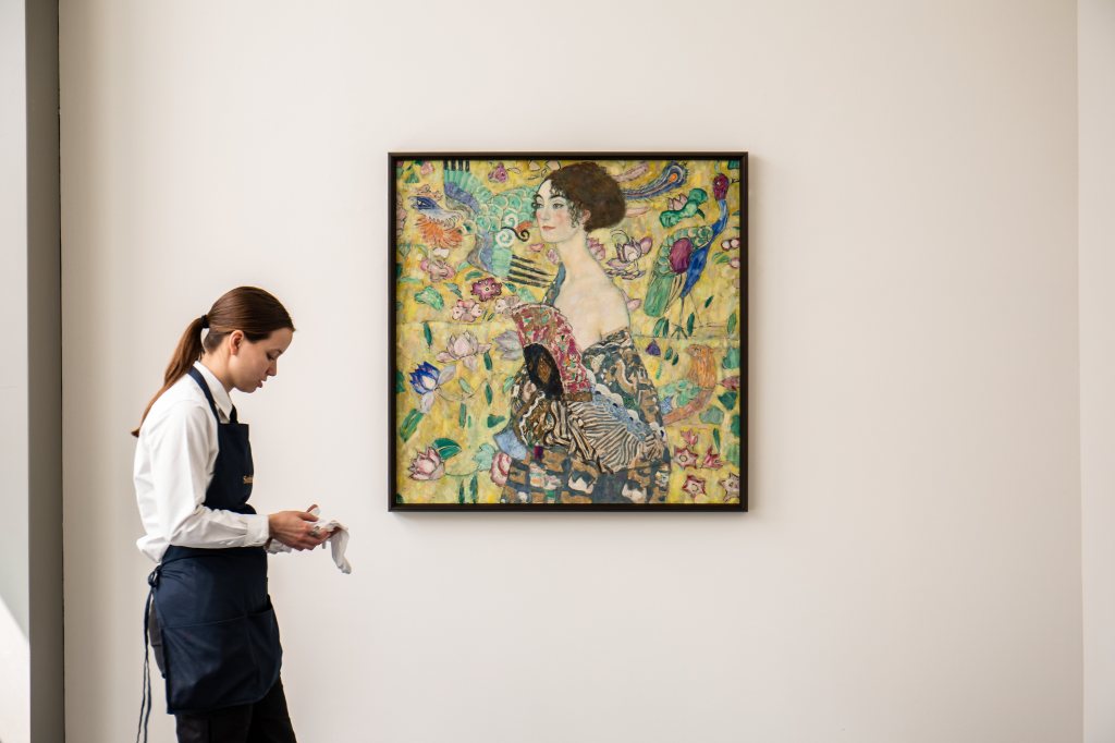 An art handler walks past Gustav Klimt's Lady with a Fan